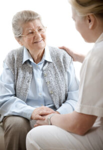 Caregiver talking with an elderly woman.