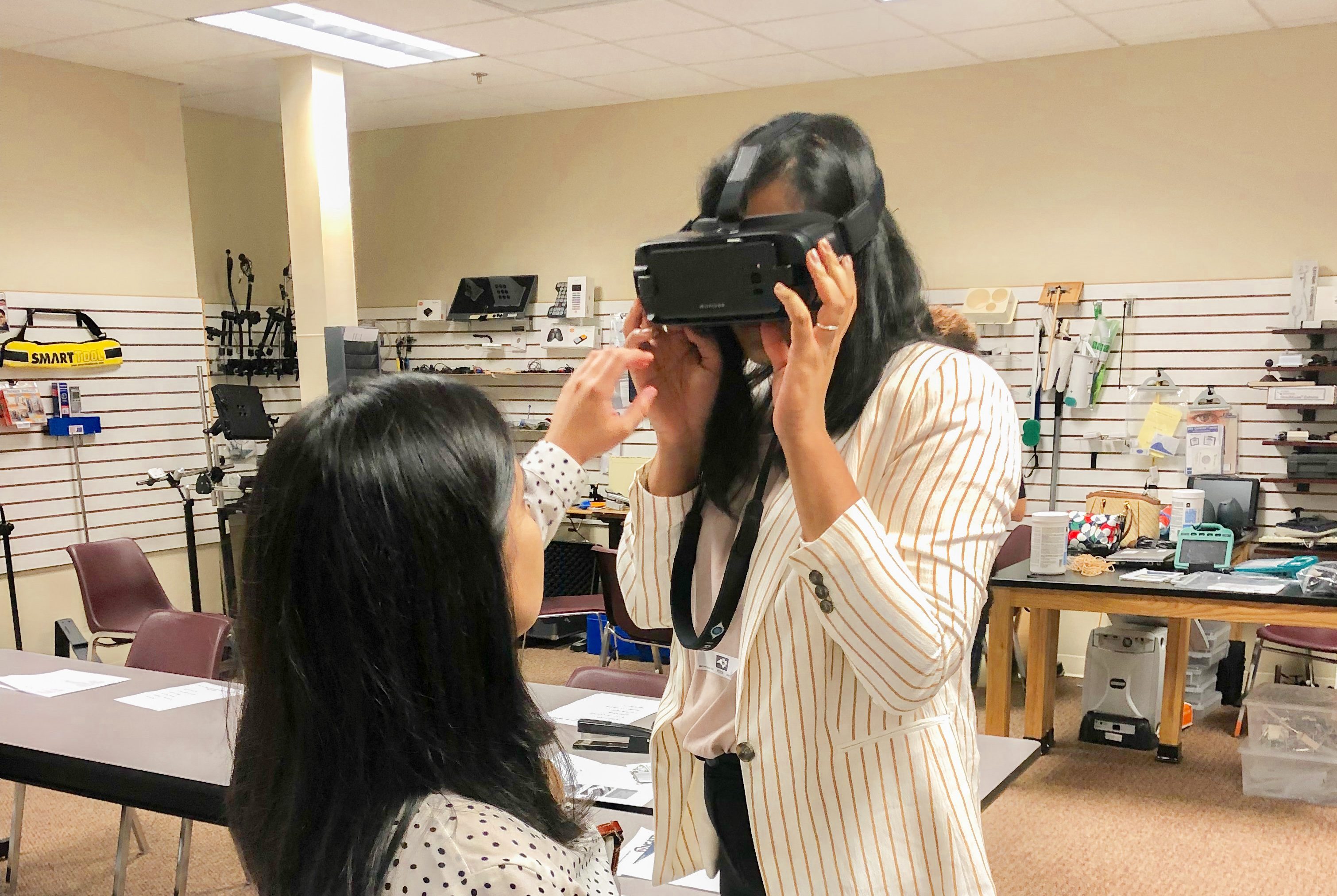 Division of Clinical Rehabilitation and Mental Health Counseling students Shreya Gunna and Osly Galobardi test out the assistive technology.