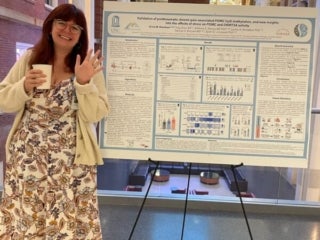 Graduate Student, Erica Branham, in front of her poster presentation