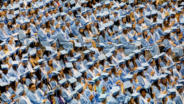 a large group of tar heel graduates waiting in their seats during commencement