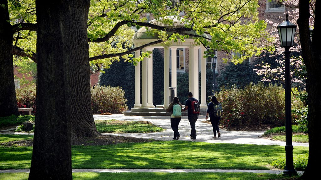Three students walk near the Old Well on UNC-Chapel Hill's campus