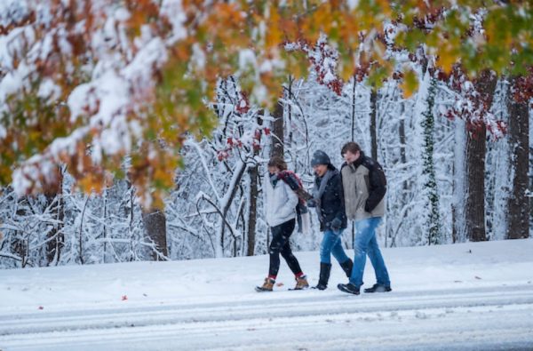 3 people walking. Winter snow blankets the campus of the University of North Carolina at Chapel Hil