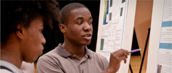 two diverse students presenting research posters