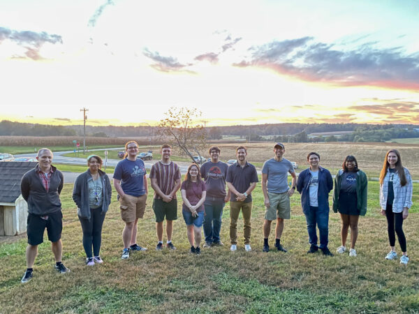 Group of students and faculty at the BP Maple view farms at sunset
