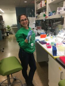 Aaztli Coria in lab with green shirt and holding a pipette