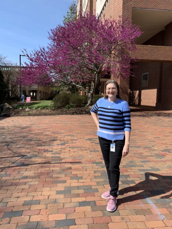 Carolyn Clabo by flowering trees on the way to campus event