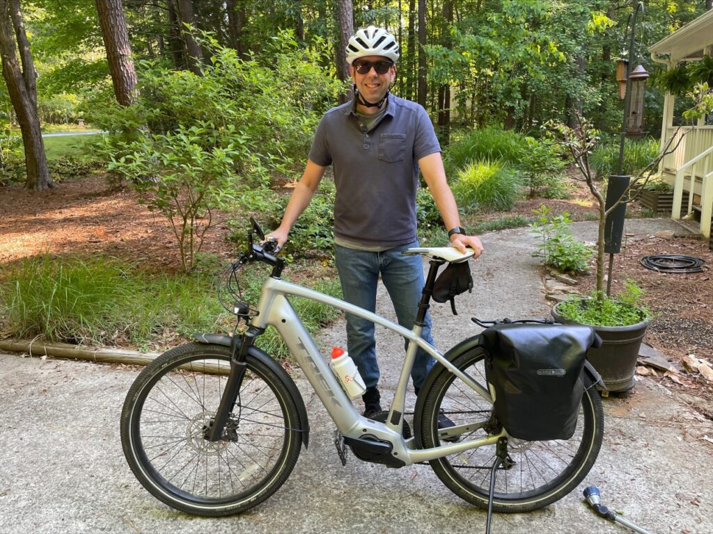 Brian Kuhlman standing with his ebike in front of his home
