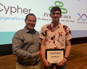 Brian Strahl with G. C. with poster award on stage