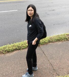 Liu Mei PhD standing by road in black clothes 