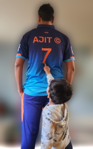 Ajit number 7 t shirt with small boy pointing