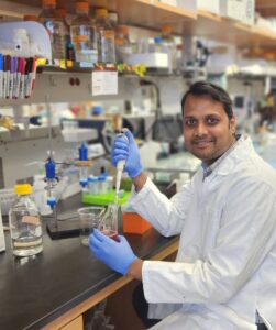 Ajit in lab with white coat