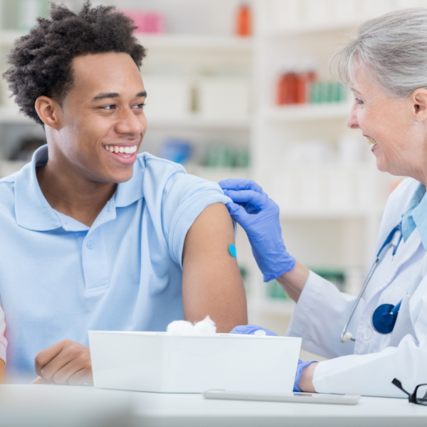 smiling man gets vaccination from healthcare worker