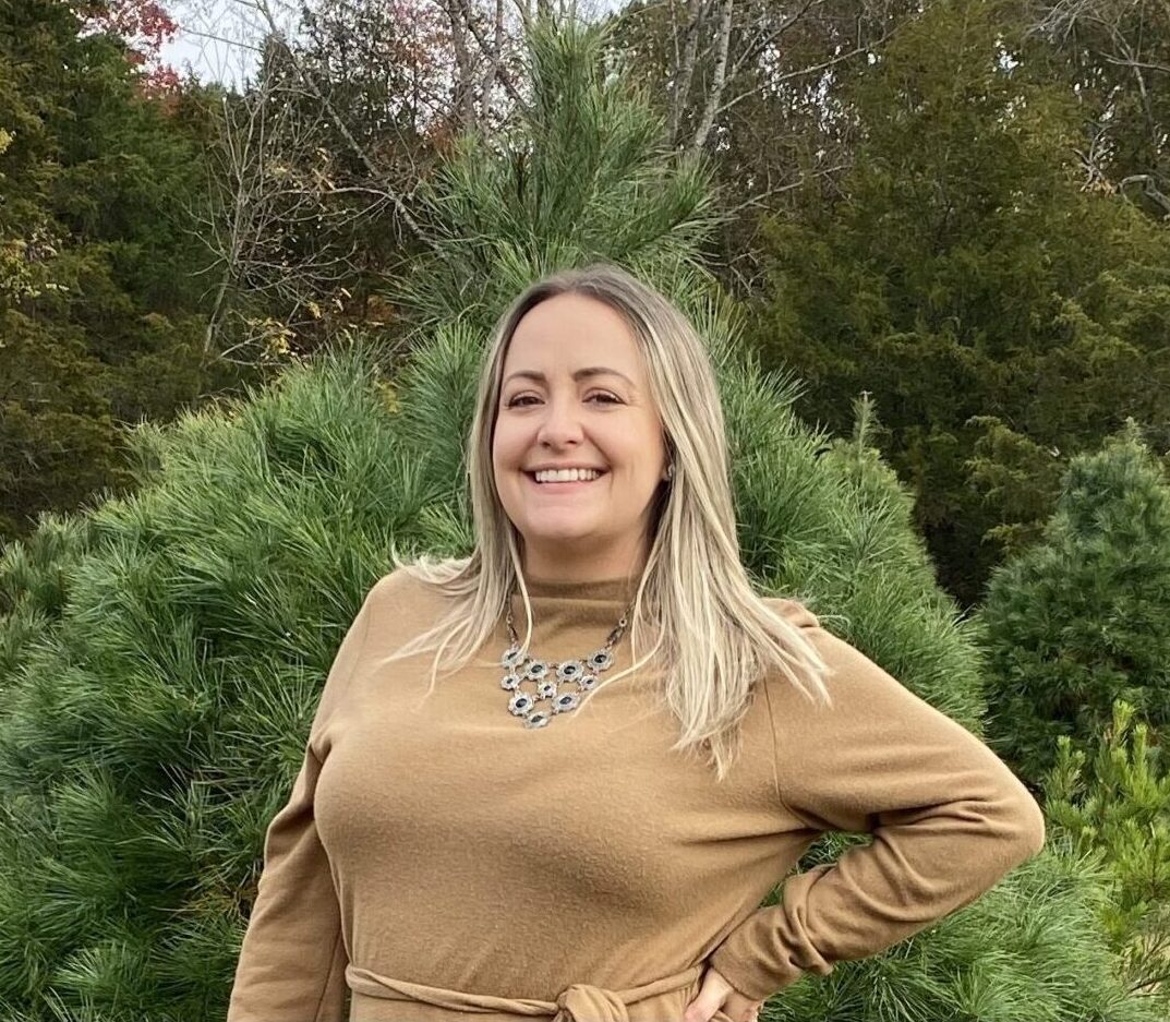 Dr. Karen Farizatto stands outside smiling in front of a tree