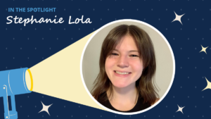 Navy blue background has diamonds and starbursts. A spotlight icon shines on a circular image of Stephanie Lola. A label reads "In the spotlight." Below the label is the text "Stephanie Lola."