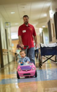 Father walks child down hallway of the hospital