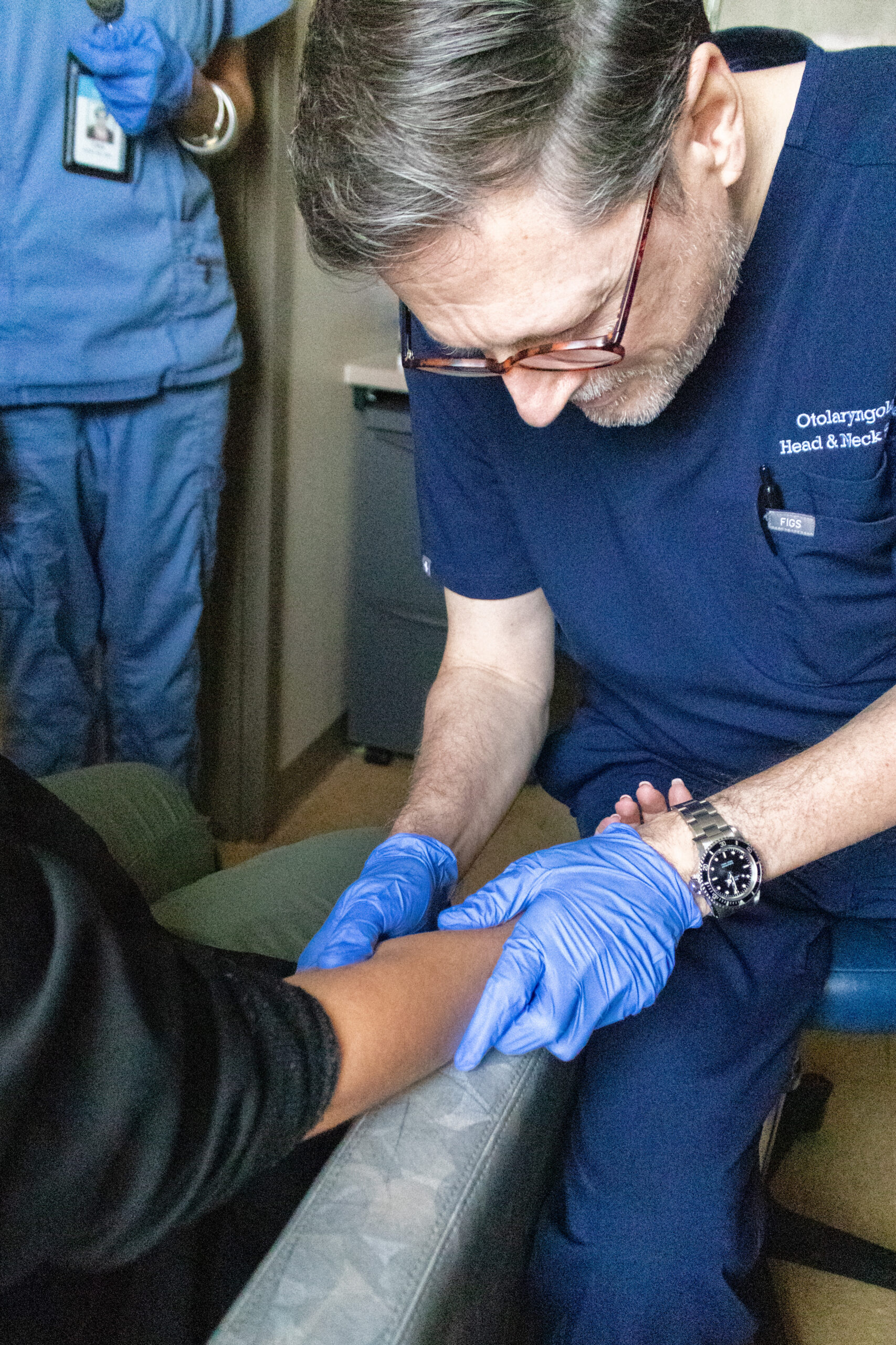 dr. senior examining a patients arm