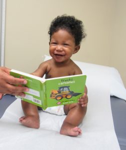 Happy baby reading a book