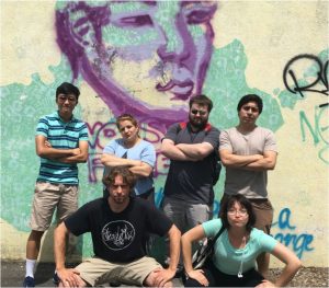 The Hirsh Lab Group pose in front of a wall with colorful graffiti.