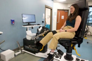 A woman performs exercise on an exercise machine