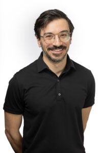 Michael Amato headshot man with short brown hair and a mustache, wearing a black shirt and glasses