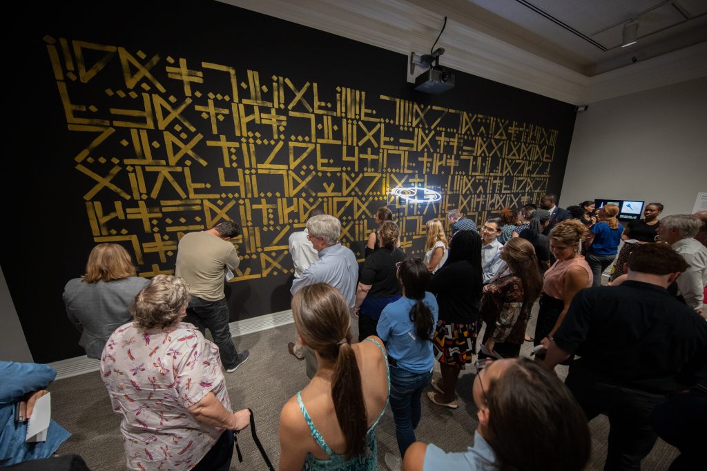 Attendees examine artwork