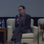 Melissa Haendel speaks into a microphone at a conference panel