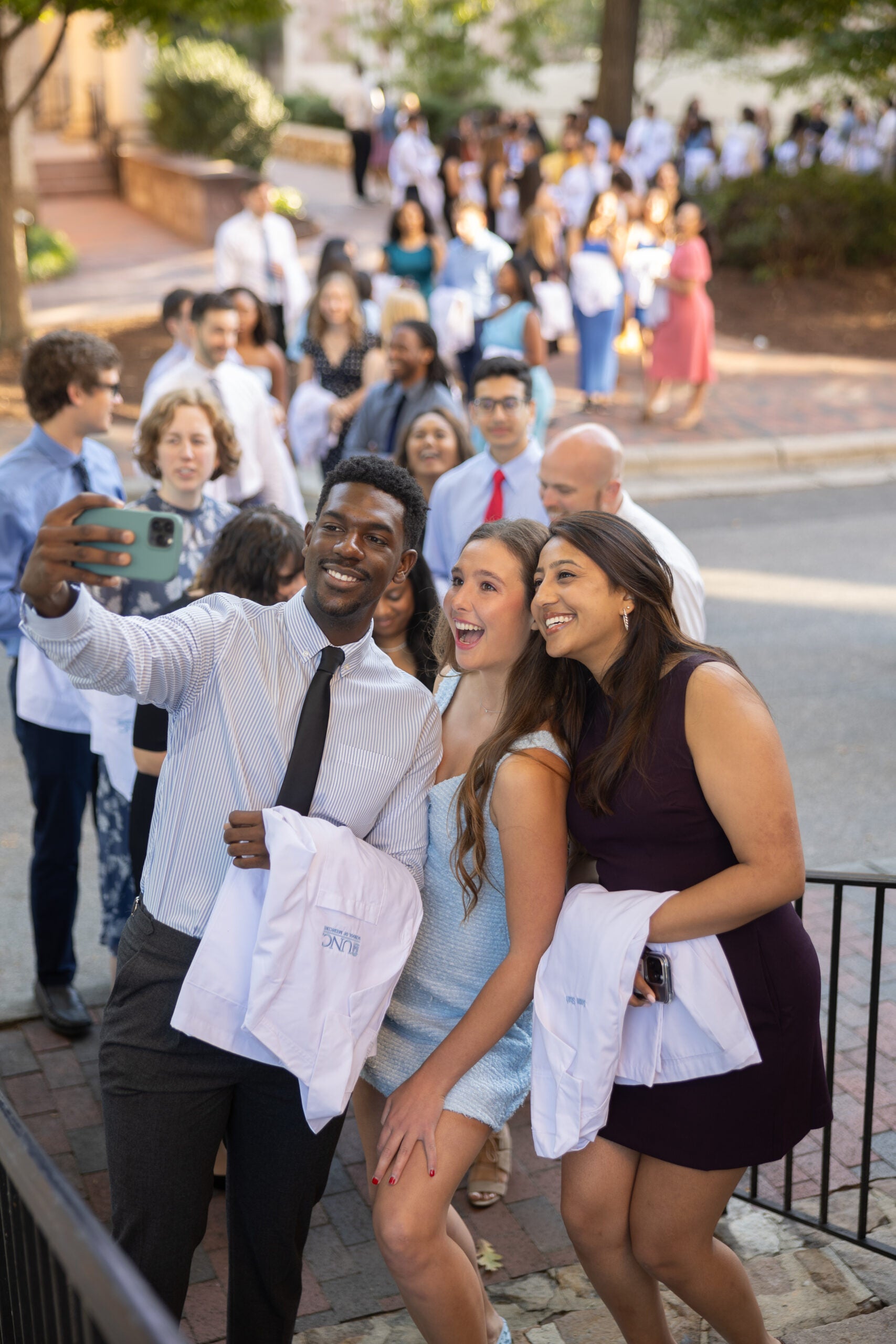 Students taking a selfie at a White Coat Ceremony