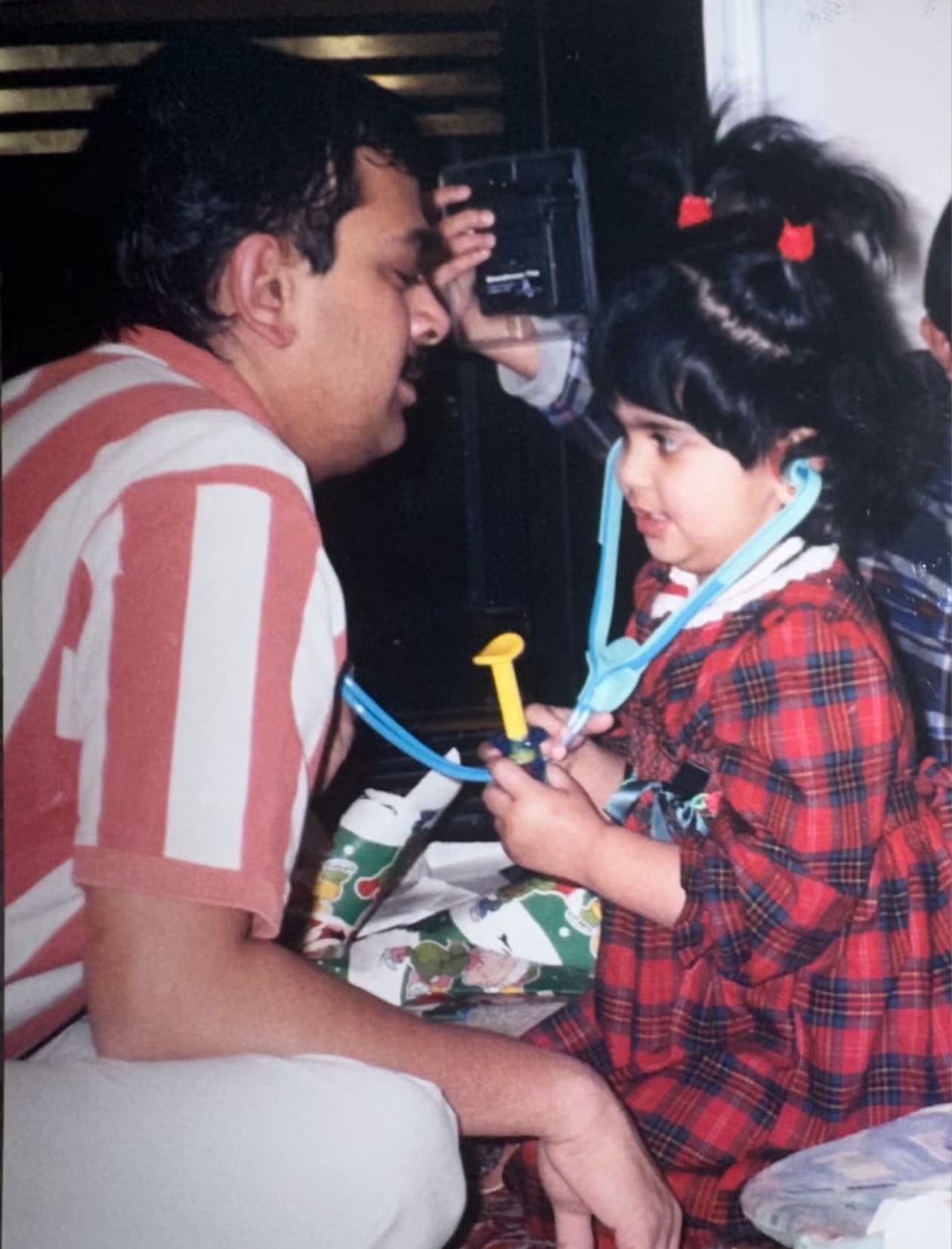 Avani Desai as a child, trying on a stethoscope.