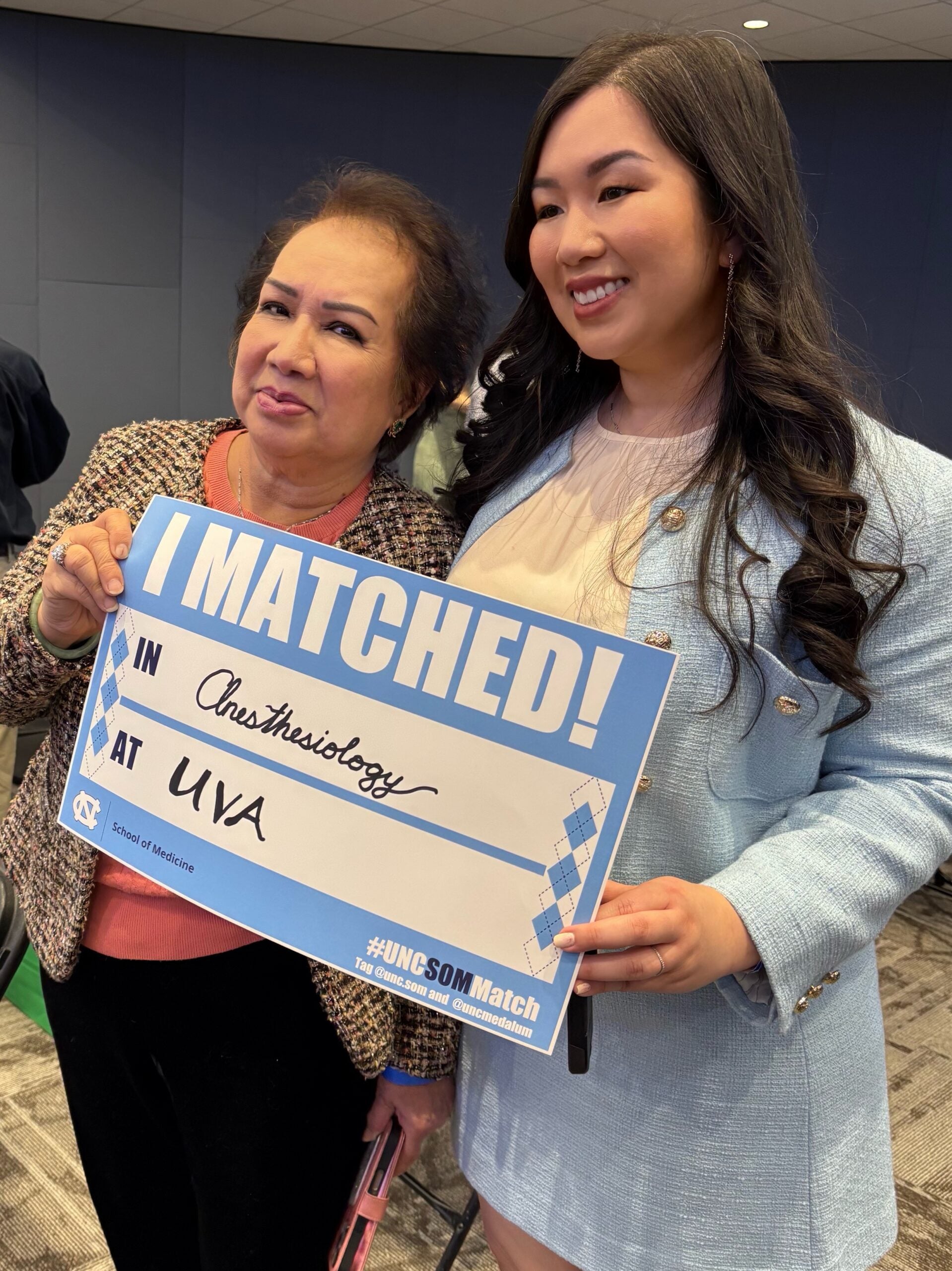 Carolina holding her Match Day sign alongside her mother.