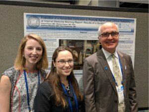 Three people standing in front of an academic poster