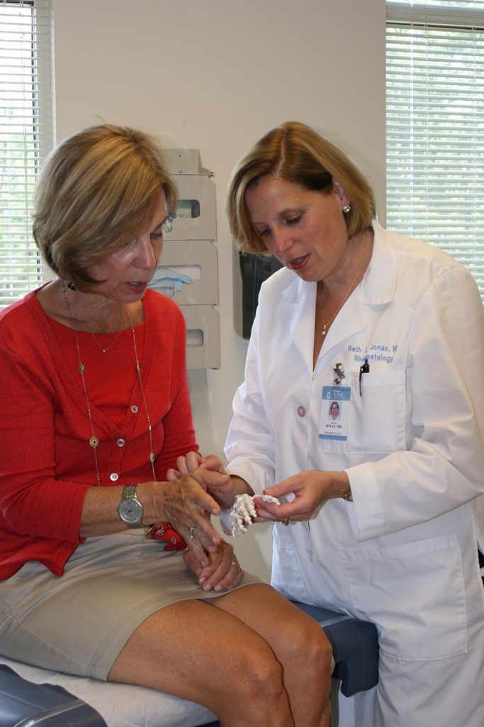 a physician uses an artificial bone model to educate a patient