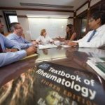 Rheumatology staff conduct a meeting at a table