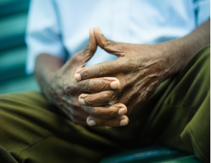 a man's geriatric hands, folder in his lap