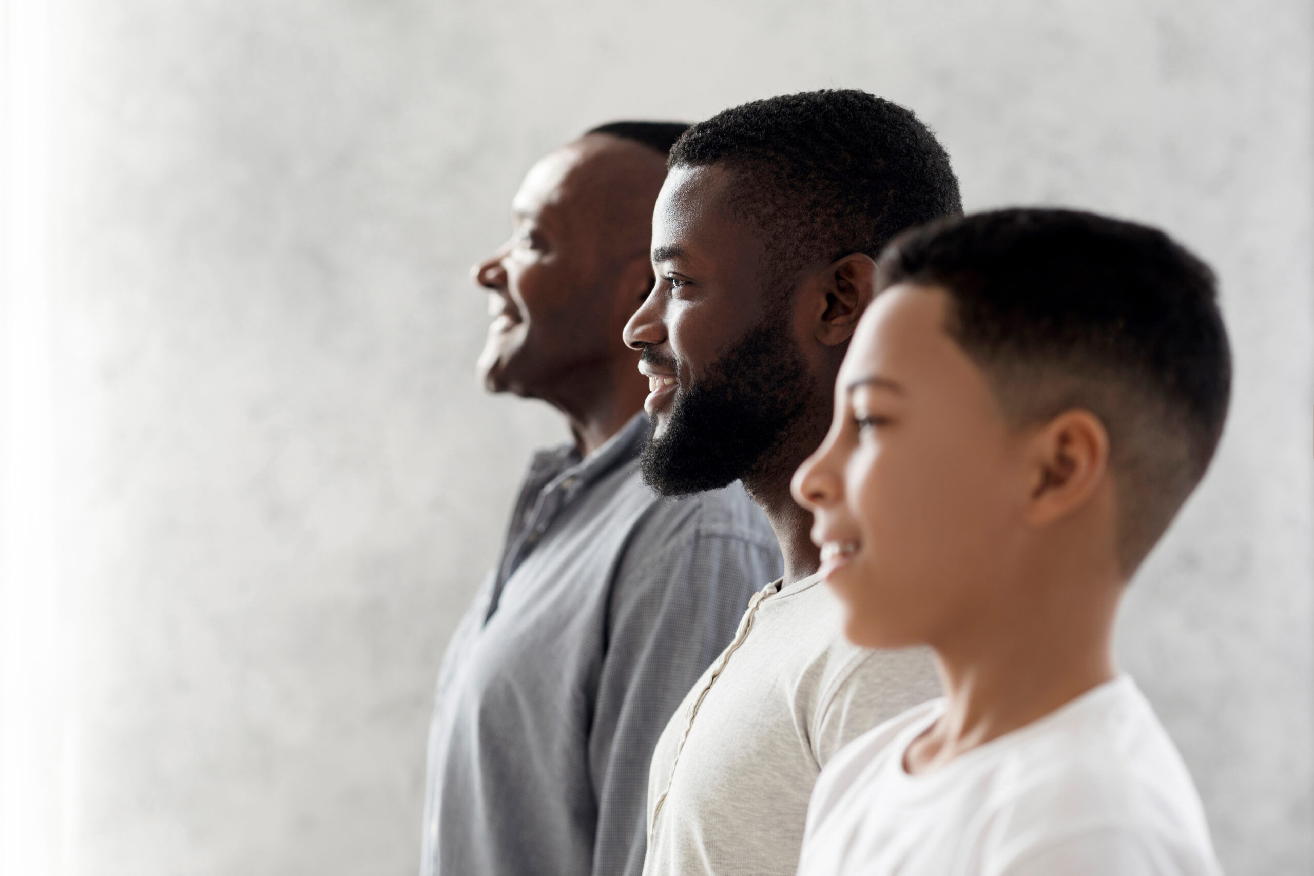 Multi Generational Male Family Portrait. Side View Of African American Son, Father And Grandfather Standing In A Row