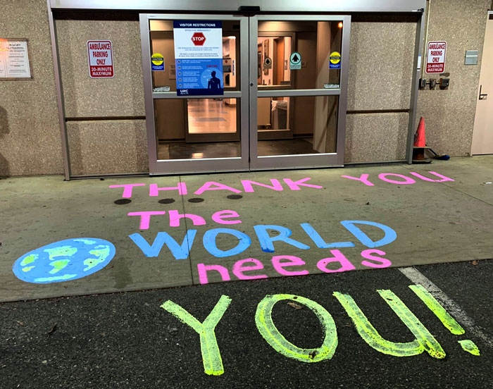 Words on sidewalk outside the Emergency entrance: Thank you, the world needs you.