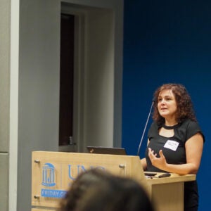Dr. Giulia Fragola presents at a podium to a seated audience during a Neurology Day 2026 lecture.