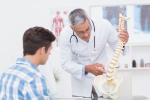 Doctor explaining a spine model to patient