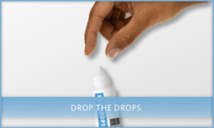 a human hand reaches towards a bottle of eye drops