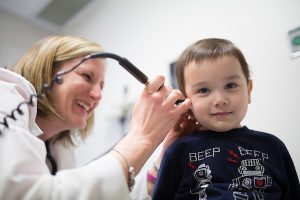 Dr. Kristen Cole checking a patients ear