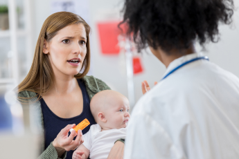 Concerned mother and baby with physician