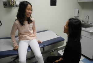 Dr. Eveline Wu in clinic with a patient