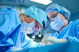 Image of two doctors conducting surgery.
