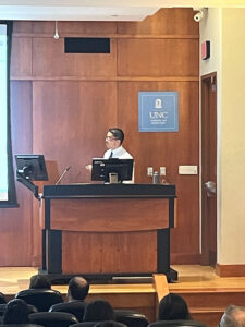 Ernesto Leon at the podium as he gives his PhD defense talk titled, “Enhancing the function and delivery of chimeric antigen receptor T-cells: Implications for treatment of solid tumors.”