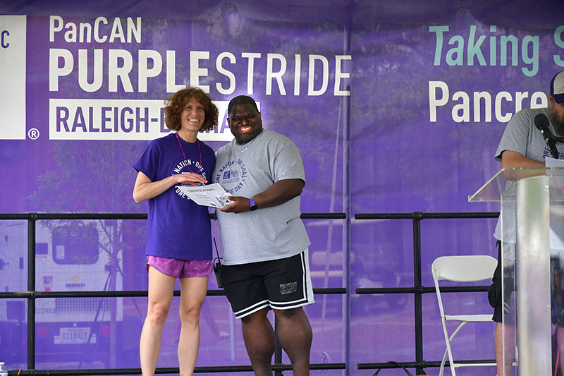 Kirsten Bryant receiving certificate as second highest fundraiser at the PurpleStride event this year