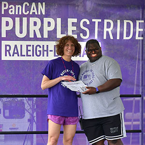 Kirsten Bryant receiving certificate as second highest fundraiser at the Raleigh-Durham PurpleStride event as this year's second highest fundraiser