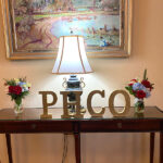 Holiday table with flowers and a sign that says PHCO