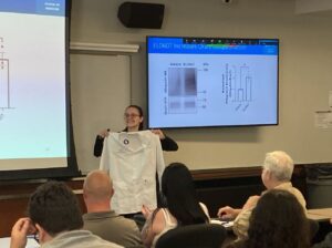 Dr. Sasha Goriounova holds her PHCO white coat at her white coat ceremony after her PhD defense presentation.