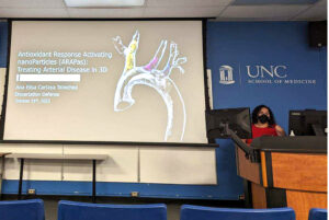 Ana Cartaya presents at her PhD defense in front of a slide of an aorta