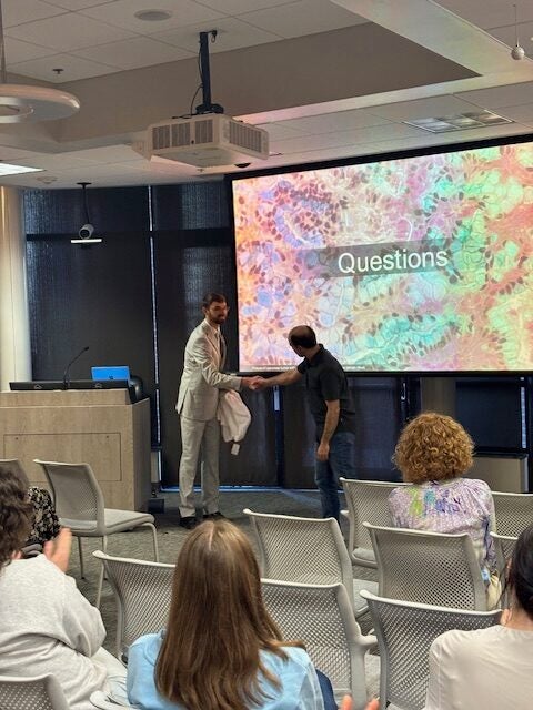 Cole P. Martin, PhD, at his defenes, being congratulated.