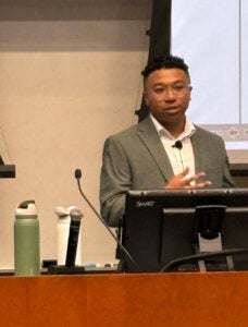 Anthony Hazelton, PhD, at the podium at his defense